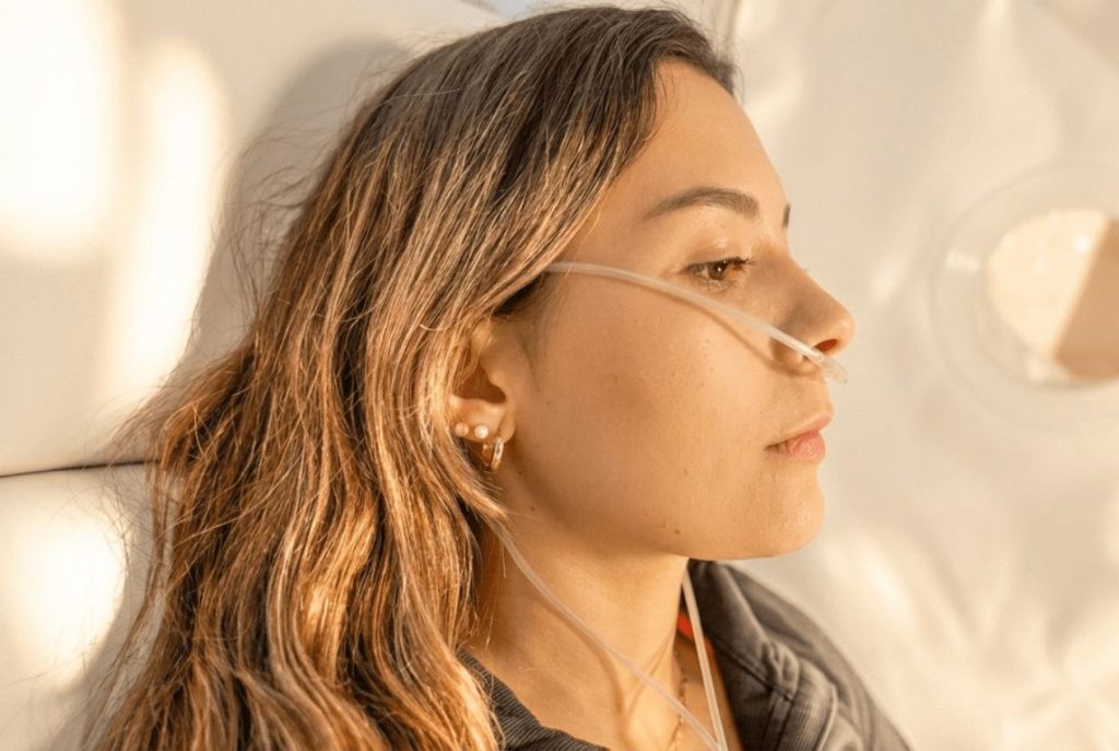 Close-up of a woman receiving oxygen through a nasal cannula during a hyperbaric oxygen therapy session for mental clarity and brain fog at SILA Miami, FL.