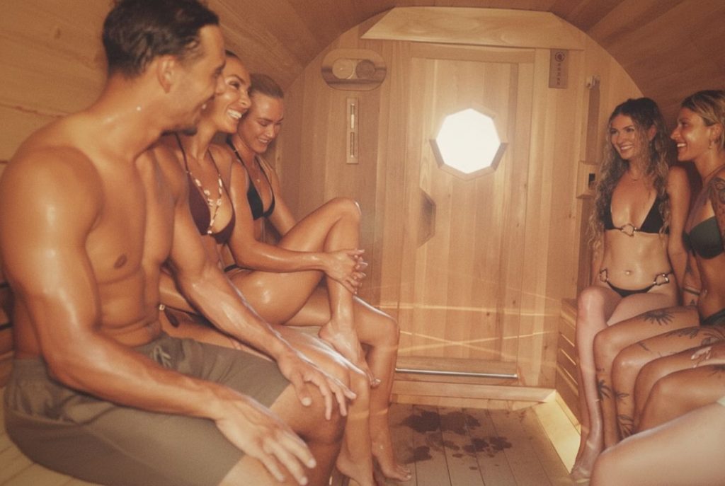 Friends relaxing inside the cedar barrel sauna at SILA Miami during a sauna for detox and recovery session in Miami, FL