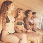 Group of four sitting inside the cedar barrel sauna at SILA Miami during a sauna for detox session in Upper Buena Vista, FL
